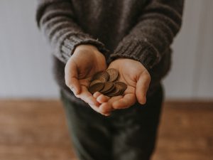 Hand Holding Coins- Benefits Of Hiring A Junk Removal Company Pensacola- Something Old Salvage 6505 North W St Pensacola Fl 32505 (850) 758- 9900 https://www.somethingoldsalvage.com